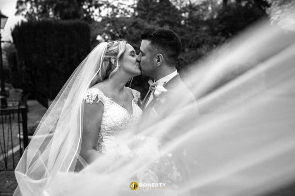 bride and groom at Ardencote Manor with veil blowing in wind