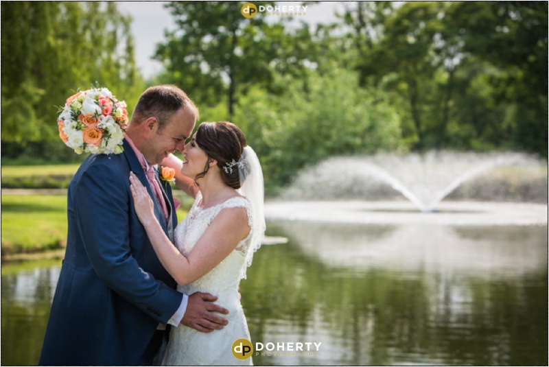 Wootton Park Bride and Groom hug by lake and fountain