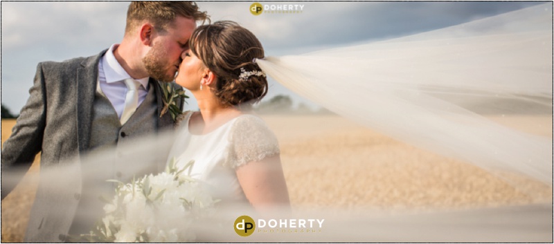 Mythe Barn Wedding couple with veil blowing in wind