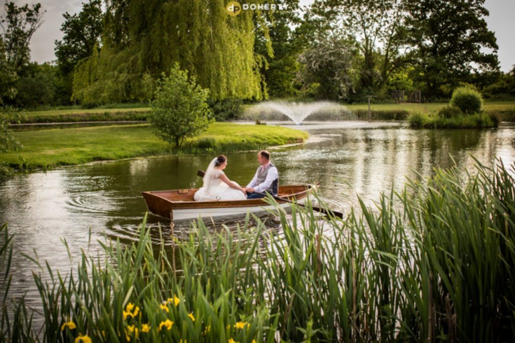 bride and groom on lake in boat