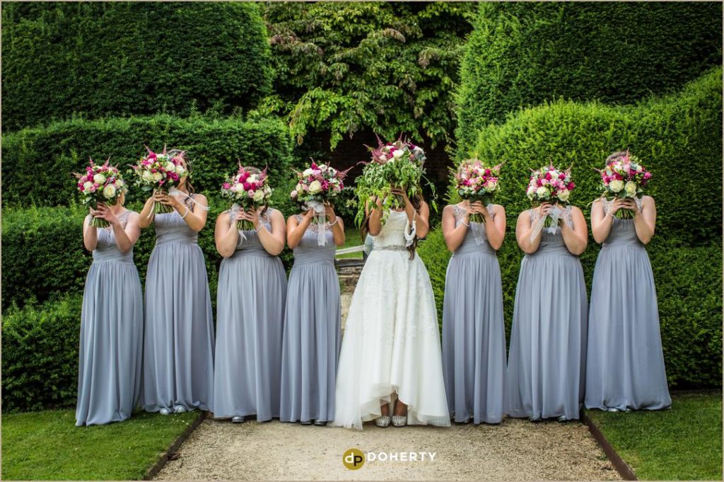 Bridesmaids with flowers over faces at Billesley Manor