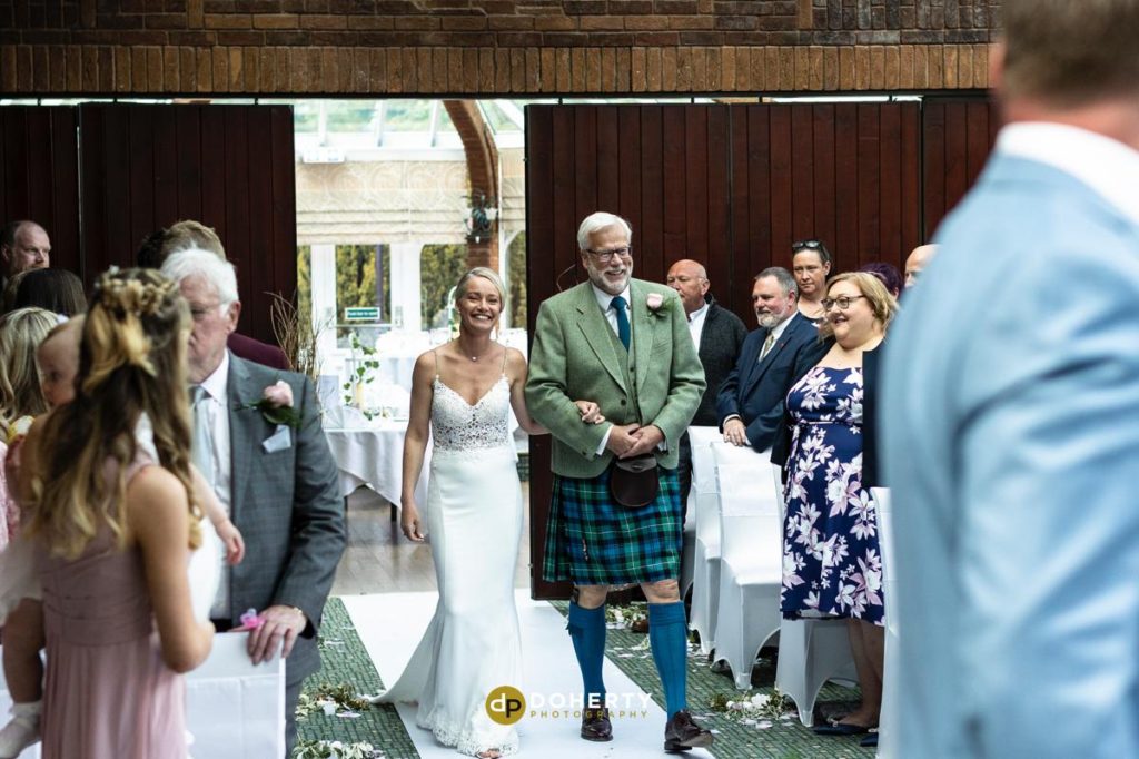 bride walks down the aisle with father - Ardencote Manor