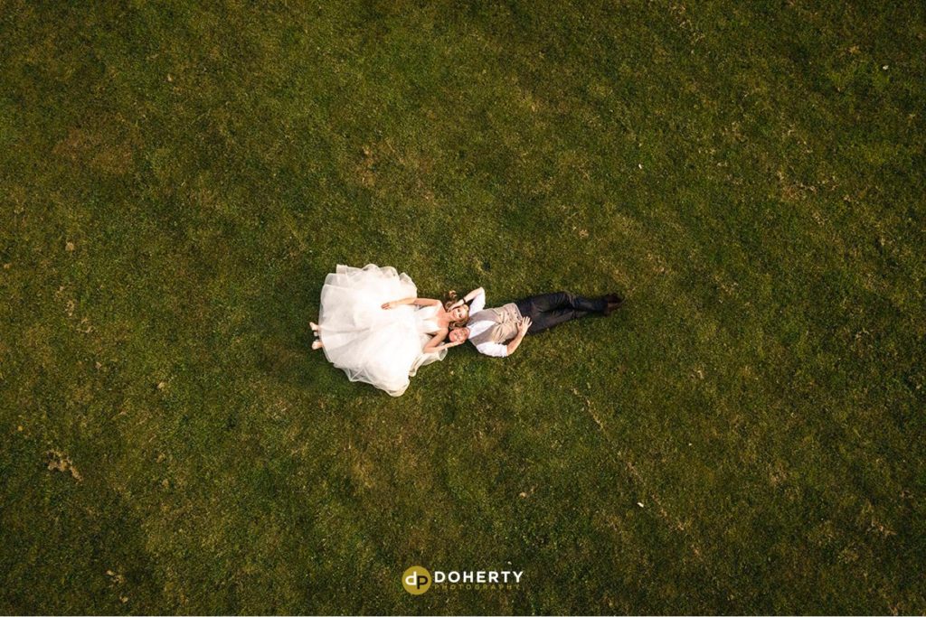Drone Photo of bride and groom lying on the floor
