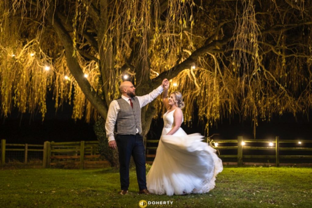 Bride an dgroom dancing outside under the tree lights at Crockwell Farm wedding