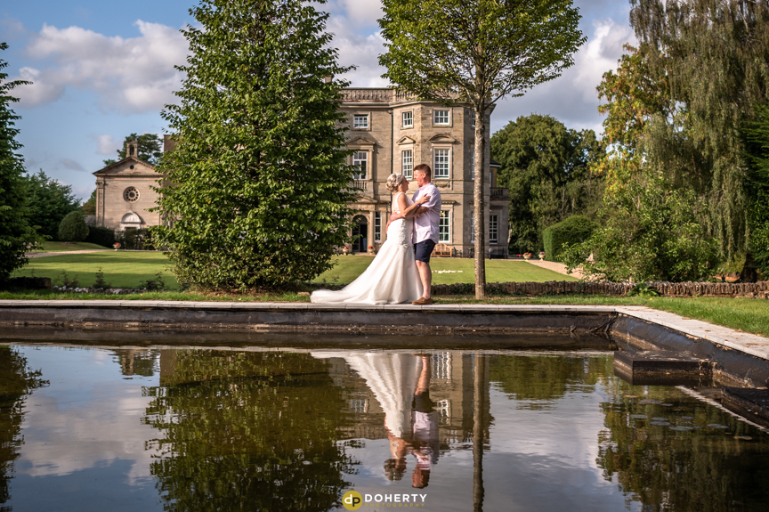 Bride and Groom by pond at Bourton Hall in Warwickshire