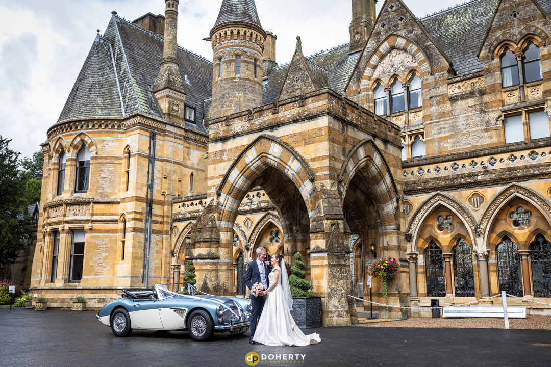 Ettington Park Wedding photo - bride and groom with car