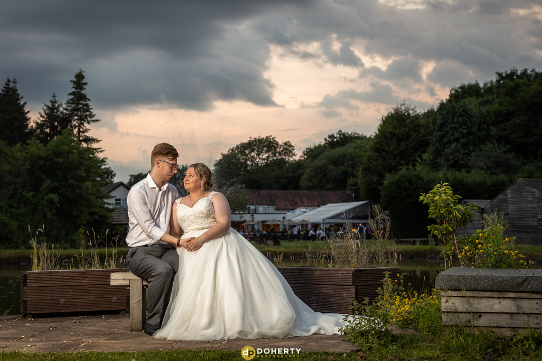 Limes Country Lodge Solihull - Bride and Groom sit at the pond during the evening
