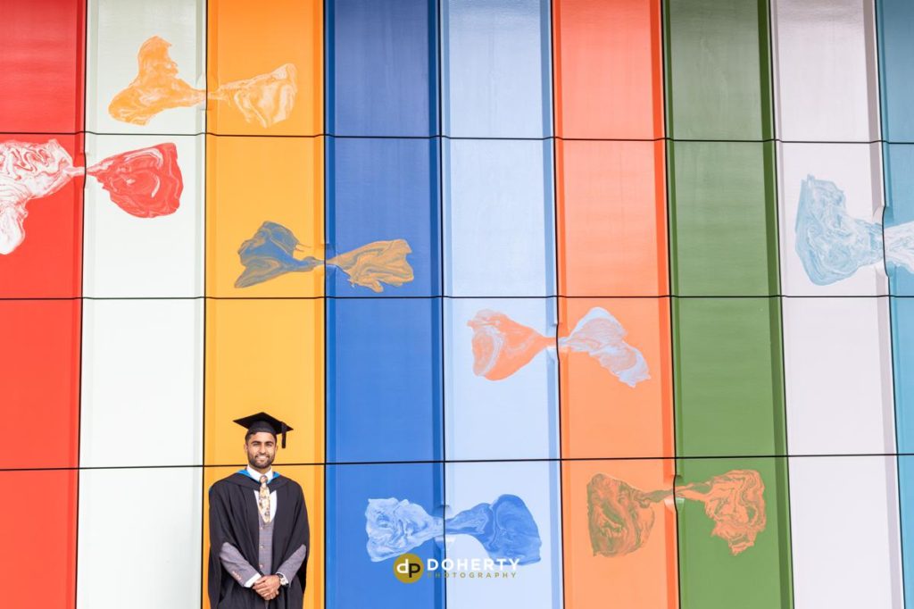 Graduation portraits of man with coloured backdrop