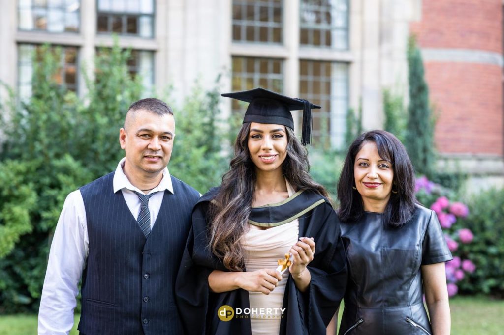 Graduation photo of young woman with parents at Birmingham University