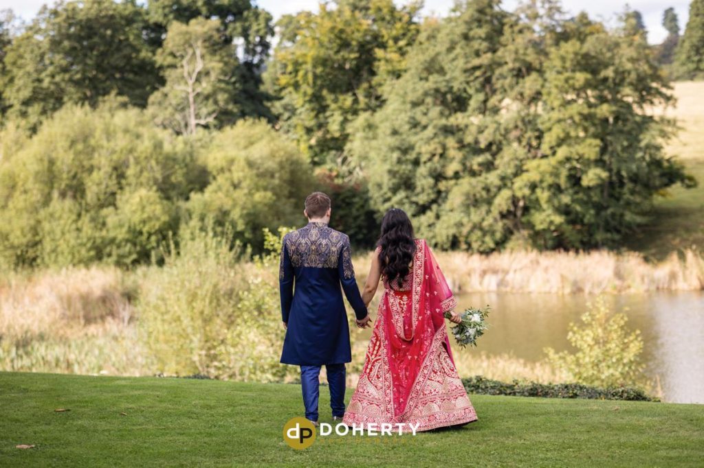 Bride and groom walking in grounds at Fawsley Hall wedding in Northamptonshire