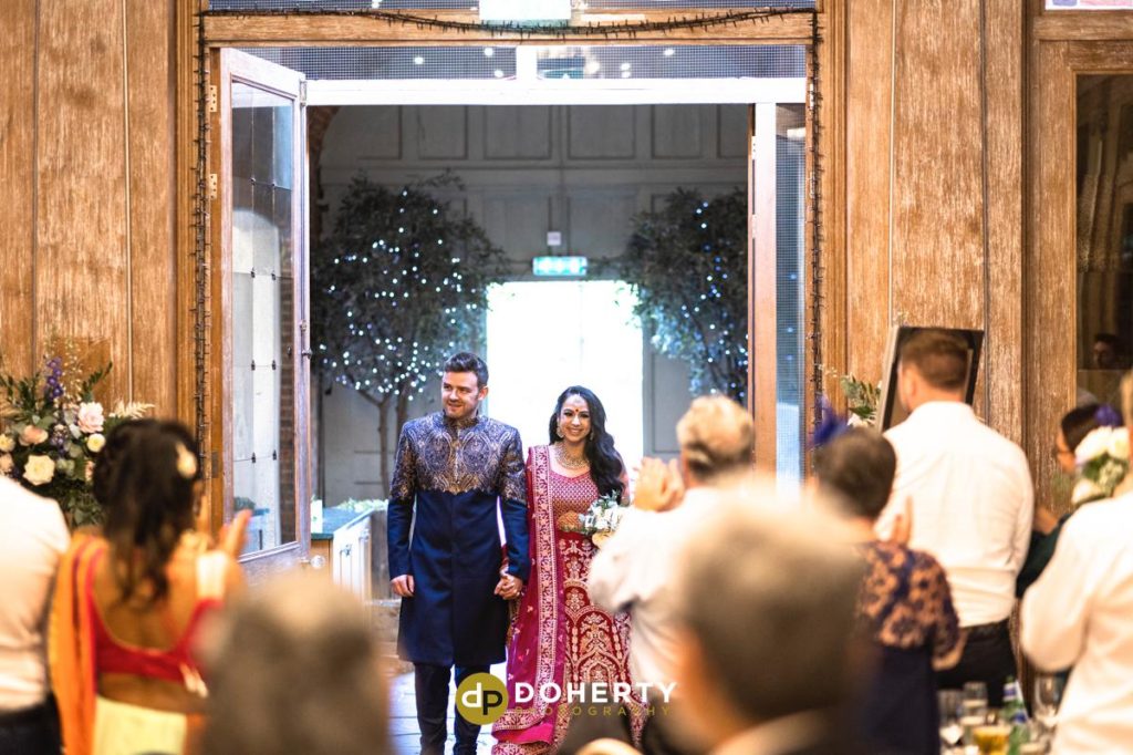Bride and groom enter reception room at Fawsley Hall wedding in Northamptonshire