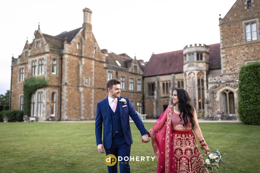 Fawsley Hall venue with bride and groom walking