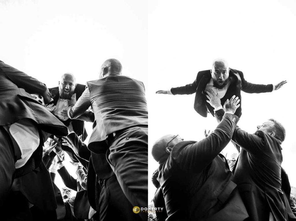 Groom being thrown by groomsmen