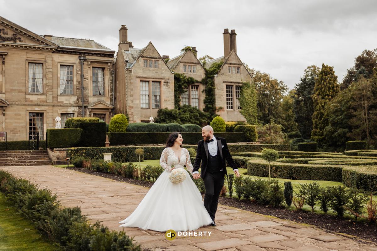 coombe abbey with bride and groom walking